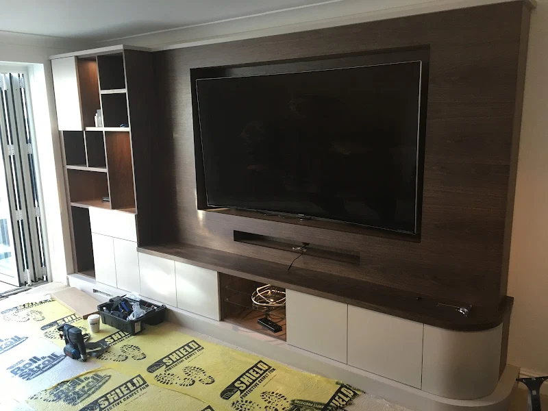 Television neatly wall-mounted on a wood-panelled feature wall with hidden cables